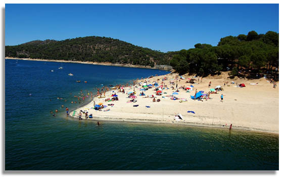 Playa en la costa del Pantano de San Juan en verano - Madrid también es una opción estupenda para vacaciones